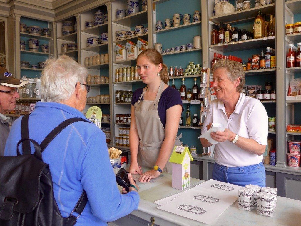 Shop owners assisting customers in a mustard shop in Ghent, Belgium. - Open Suitcase