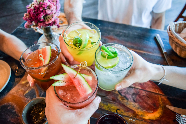 friends toasting happy hour with pretty cocktails