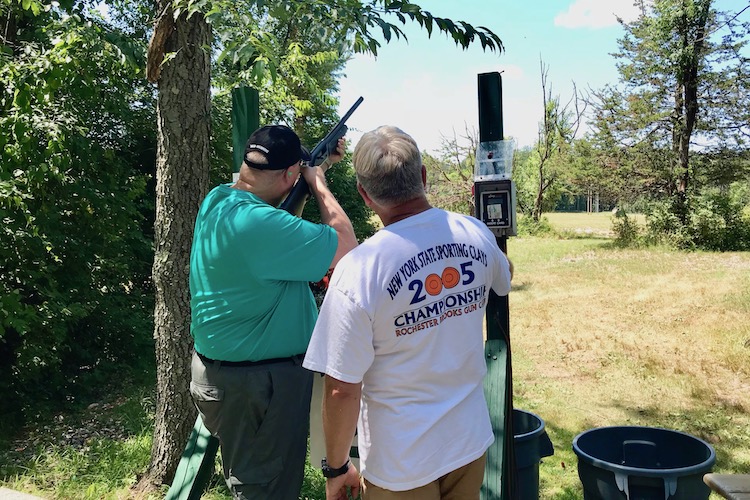 Two men shooting clay pigeons on a skeet field