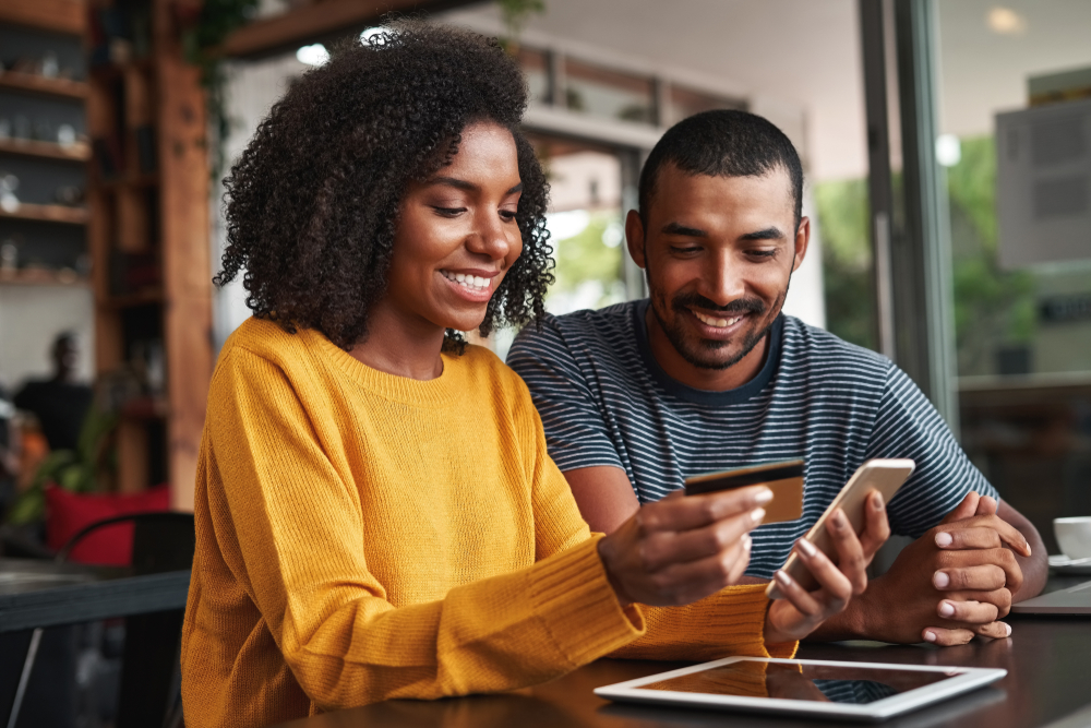 Black couple check credit card statement for annual travel credit